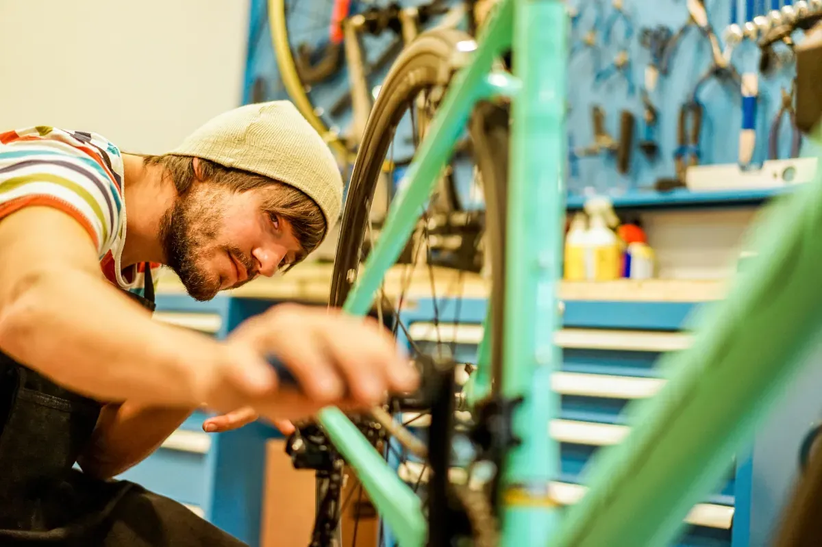 stylish-bearded-bicycle-mechanic-doing-his-profes